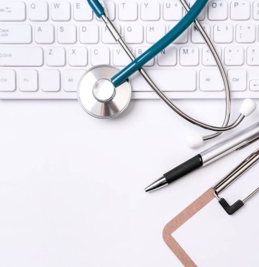 Beyaz masa arka planı üzerinde klavye üzerinde Stetoskop. Online tıbbi bilgi tedavi teknolojisi ofis konsepti, üst görünüm, düz yatıyordu, kopyalama alanı