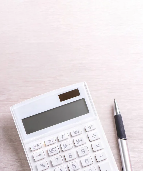 Calculadora branca e caneta em mesa de madeira brilhante, análise e estatísticas de lucro financeiro, conceito de risco de investimento, espaço de cópia, vista superior flat lay — Fotografia de Stock