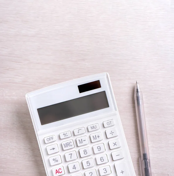 Белый калькулятор и ручка на светлом деревянном столе, аналитика и статистика финансовой прибыли, концепция инвестиционных рисков, копировальная площадка, вид сверху квартиры — стоковое фото