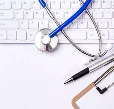 Stetoskop beyaz arka plan üzerinde bilgisayar klavyesi üzerinde. Hekim tıbbi durumda uzun vadeli bakım tedavi kavramı, üst görünüm, düz yatıyordu, kopyalama alanı yazmak