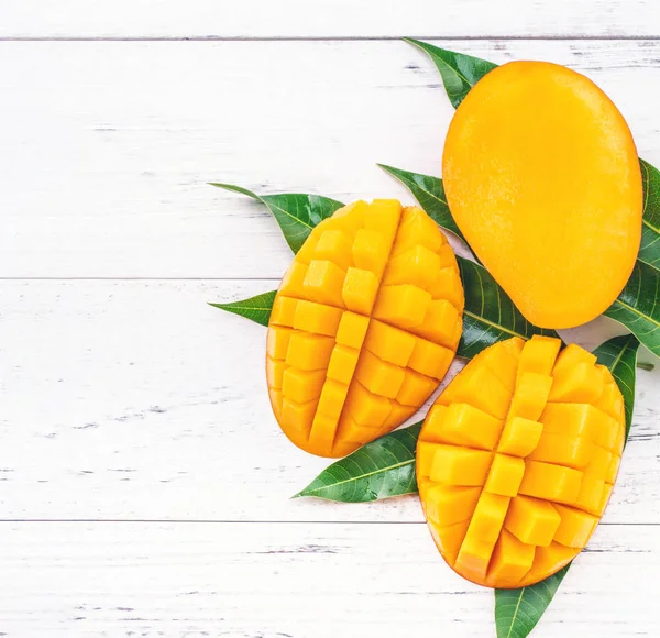 Vacker hackad Mango med gröna blad på ljust vit färg timmer bakgrund. Ovanför ovanifrån, platt Lay, kopiera utrymme, närbild. Tropiska frukter Concept. — Stockfoto