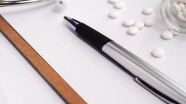 Tıbbi Konsept - Beyaz bilgisayar klavyesi ve yanında ilaçlar üzerinde mavi stetoskop ile Doktor ofisi çalışma masası. Kamyon sol, yakın çekim, makro.