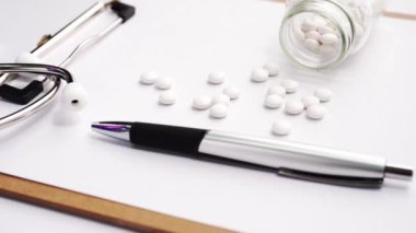 Tıbbi Konsept - Beyaz bilgisayar klavyesi ve yanında ilaçlar üzerinde mavi stetoskop ile Doktor ofisi çalışma masası. Kamyon sol, yakın çekim, makro.