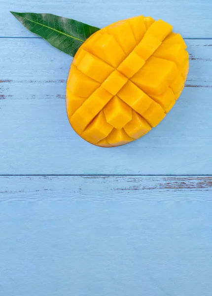 Färsk Mango-vacker hackad frukt med gröna blad på klarblå timmer bakgrund. Designkoncept för tropiska frukter. Flat Lay. Översta vyn. Kopiera utrymme — Stockfoto