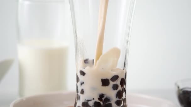 在明亮的大理石桌上用美味的流行台湾木薯珍珠泡在饮料杯中倒入奶茶 食谱概念 视频拍摄 — 图库视频影像