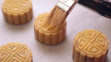 Pişirme den önce ev yapımı kanton ay kek - Kadın geleneksel festival için fırın tepsisine fırça ile pasta üzerine yumurta bulaşma, yakın.