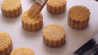Pişirme den önce ev yapımı kanton ay kek - Kadın geleneksel festival için fırın tepsisine fırça ile pasta üzerine yumurta bulaşma, yakın.