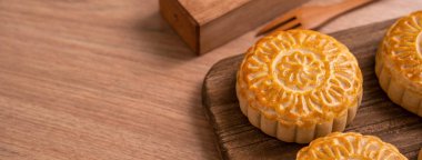 Yuvarlak şekilli ay kek Mooncake - Orta Sonbahar Festivali sırasında Çin tarzı geleneksel pasta / Ahşap arka plan ve tepsi üzerinde Ay Festivali, yakın