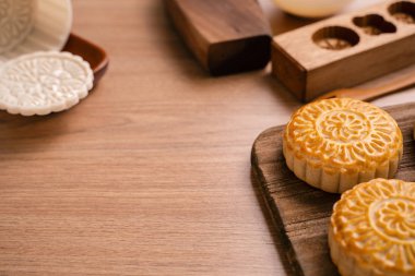 Yuvarlak şekilli ay kek Mooncake - Orta Sonbahar Festivali sırasında Çin tarzı geleneksel pasta / Ahşap arka plan ve tepsi üzerinde Ay Festivali, yakın