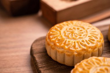 Yuvarlak şekilli ay kek Mooncake - Orta Sonbahar Festivali sırasında Çin tarzı geleneksel pasta / Ahşap arka plan ve tepsi üzerinde Ay Festivali, yakın