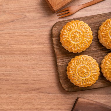 Yuvarlak şekilli ay kek Mooncake - Orta Sonbahar Festivali sırasında Çin tarzı pasta / Ay Festivali ahşap arka plan ve tepsi, üst görünüm, düz yatıyordu.