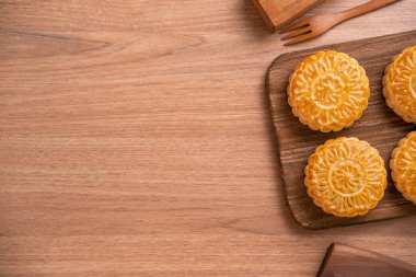 Yuvarlak şekilli ay kek Mooncake - Orta Sonbahar Festivali sırasında Çin tarzı pasta / Ay Festivali ahşap arka plan ve tepsi, üst görünüm, düz yatıyordu.