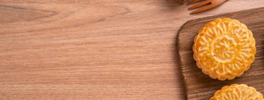 Yuvarlak şekilli ay kek Mooncake - Orta Sonbahar Festivali sırasında Çin tarzı pasta / Ay Festivali ahşap arka plan ve tepsi, üst görünüm, düz yatıyordu.