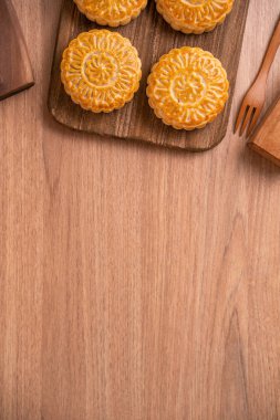 Yuvarlak şekilli ay kek Mooncake - Orta Sonbahar Festivali sırasında Çin tarzı pasta / Ay Festivali ahşap arka plan ve tepsi, üst görünüm, düz yatıyordu.