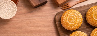 Yuvarlak şekilli ay kek Mooncake - Orta Sonbahar Festivali sırasında Çin tarzı pasta / Ay Festivali ahşap arka plan ve tepsi, üst görünüm, düz yatıyordu.