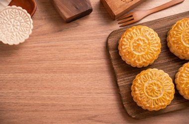Yuvarlak şekilli ay kek Mooncake - Orta Sonbahar Festivali sırasında Çin tarzı pasta / Ay Festivali ahşap arka plan ve tepsi, üst görünüm, düz yatıyordu.