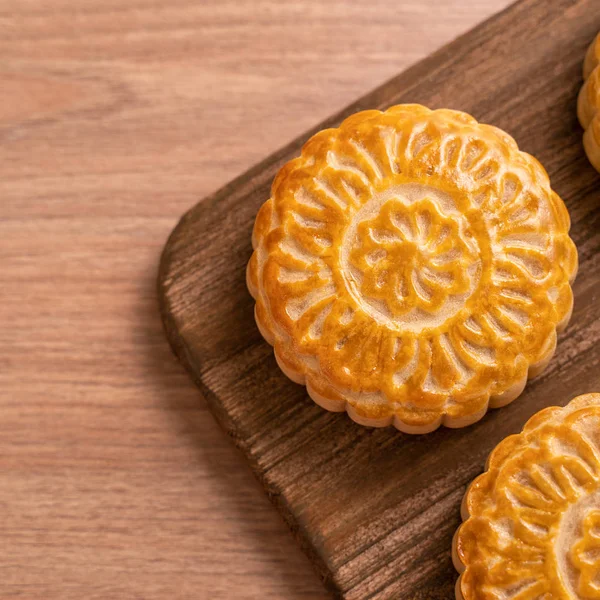 Yuvarlak şekilli ay kek Mooncake - Orta Sonbahar Festivali sırasında Çin tarzı pasta / Ay Festivali ahşap arka plan ve tepsi, üst görünüm, düz yatıyordu.