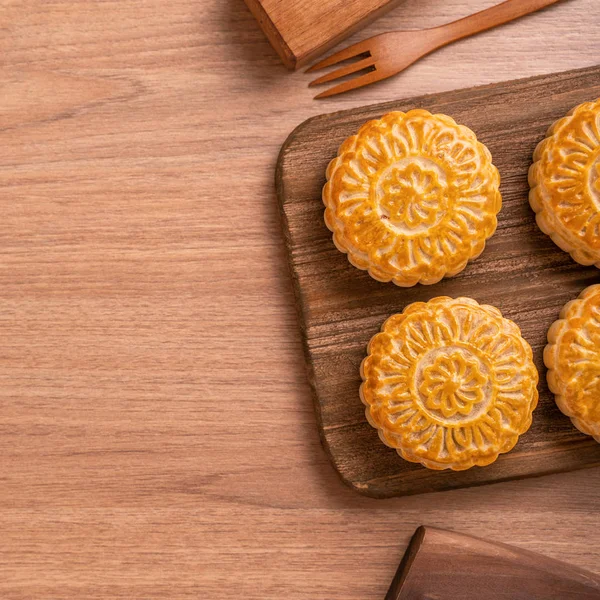 Yuvarlak şekilli ay kek Mooncake - Orta Sonbahar Festivali sırasında Çin tarzı pasta / Ay Festivali ahşap arka plan ve tepsi, üst görünüm, düz yatıyordu.