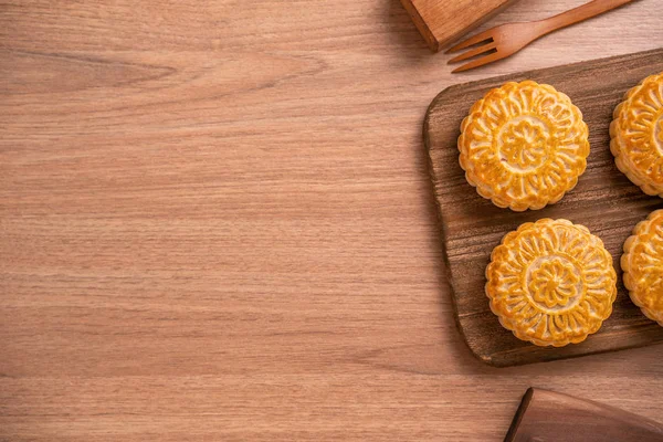 Yuvarlak şekilli ay kek Mooncake - Orta Sonbahar Festivali sırasında Çin tarzı pasta / Ay Festivali ahşap arka plan ve tepsi, üst görünüm, düz yatıyordu.