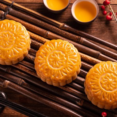 Ay kek Mooncake masa ayarı-ahşap arka planda çay bardağı ile Çin geleneksel pasta, sonbahar ortası festivali kavramı, üst görünüm, düz yatıyordu.