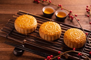 Ay kek Mooncake masa ayarı-ahşap arka planda çay bardağı ile Çin geleneksel pasta, sonbahar ortası festivali kavramı, üst görünüm, düz yatıyordu.