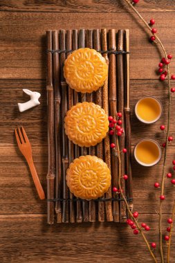 Yaratıcı ay pastaları, mooncakes masa tasarımı-ahşap arka planda çay bardağı ile Çin geleneksel pasta, Orta Sonbahar Festivali kavramı, üst görünüm, düz yatıyordu.