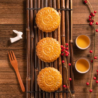 Yaratıcı ay pastaları, mooncakes masa tasarımı-ahşap arka planda çay bardağı ile Çin geleneksel pasta, Orta Sonbahar Festivali kavramı, üst görünüm, düz yatıyordu.