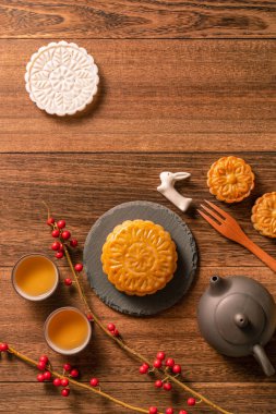 Yaratıcı ay pastaları, mooncakes masa tasarımı-ahşap arka planda çay bardağı ile Çin geleneksel pasta, Orta Sonbahar Festivali kavramı, üst görünüm, düz yatıyordu.