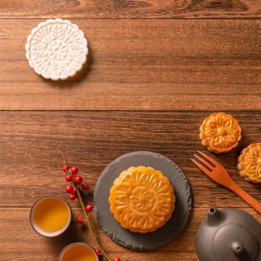 Yaratıcı ay pastaları, mooncakes masa tasarımı-ahşap arka planda çay bardağı ile Çin geleneksel pasta, Orta Sonbahar Festivali kavramı, üst görünüm, düz yatıyordu.
