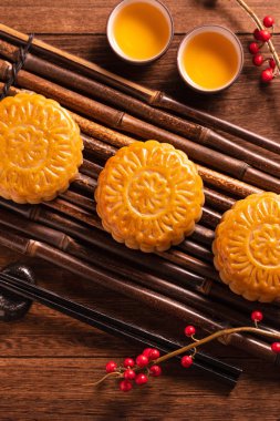 Ay kek Mooncake masa ayarı-ahşap arka planda çay bardağı ile Çin geleneksel pasta, sonbahar ortası festivali kavramı, üst görünüm, düz yatıyordu.