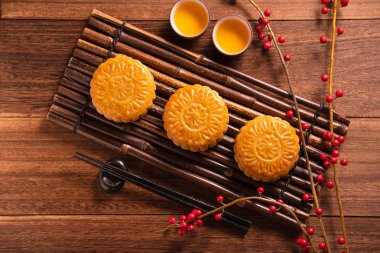 Ay kek Mooncake masa ayarı-ahşap arka planda çay bardağı ile Çin geleneksel pasta, sonbahar ortası festivali kavramı, üst görünüm, düz yatıyordu.