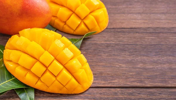 Färsk Mango-vacker hackad frukt med gröna blad på mörka trä timmer bakgrund. Designkoncept för tropiska frukter. Flat Lay. Översta vyn. Kopiera utrymme — Stockfoto