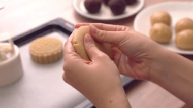 Kırmızı fasulye hamur ile ay pasta pasta yapma kadın Mooncake hamur sarma doldurma, geleneksel Orta Sonbahar Festivali için festival pişirme, yakın yukarı.