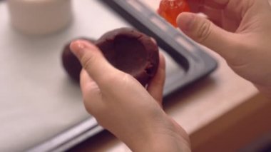 Kırmızı fasulye hamur içine doldurulmuş yumurta sarısı ile doldurma ay pasta pasta yapma kadın, geleneksel Orta Sonbahar Festivali için festival pişirme, yakın yukarı.