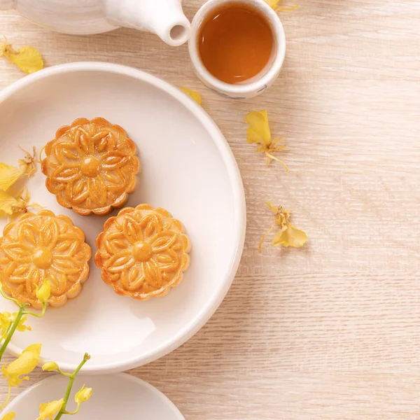 Delicious moon cake for Mid-Autumn festival with beautiful pattern, decorated with yellow flowers and tea. Concept of festive afternoon pastry design — Stock Photo, Image