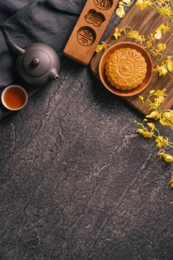 Sonbahar Ortası Festivali geleneksel gıda konsepti - Çay, pasta kalıbı, çiçek, üst görünüm, düz yatıyordu, kopya alanı ile siyah kayrak masada Beautiful Moon kek