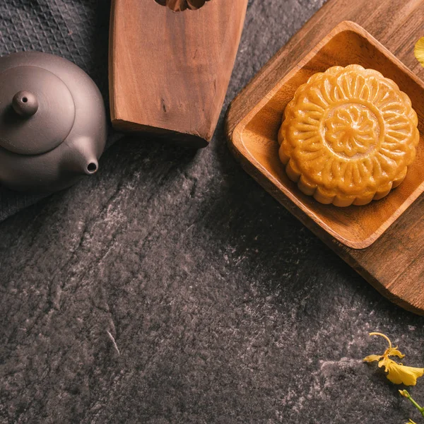 Střední podzimní festival tradiční potravinový koncept-krásný měsíční dort na stůl černá břidlice s čajem, cukrářská plíseň, květina, vrcholový pohled, plochý ležel, kopírovací prostor — Stock fotografie