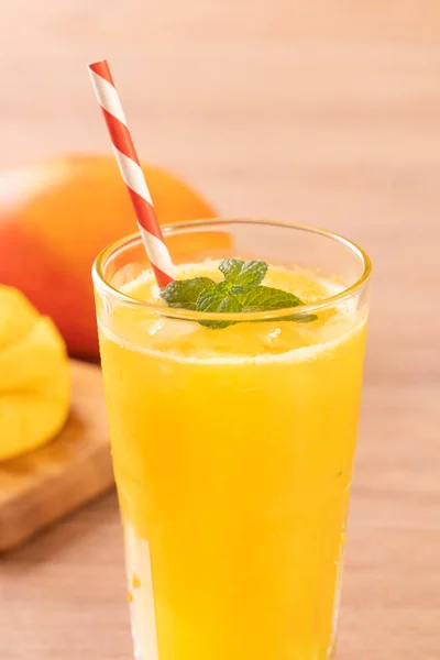 Fresh mango juice with beautiful chopped pulp flesh and straw on bright wooden table background. Tropical fruit design concept. Close up, copy space. — Stock Photo, Image