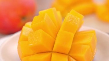Güzel taze doğranmış mango, dönen beyaz plaka üzerinde gösteren, yakın çekim, 4k video çekim.