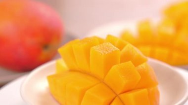 Güzel taze doğranmış mango, dönen beyaz plaka üzerinde gösteren, yakın çekim, 4k video çekim.