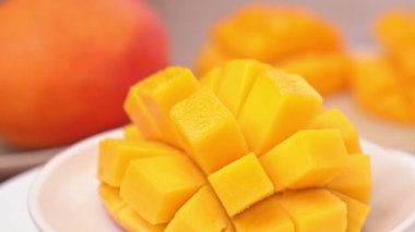 Güzel taze doğranmış mango, dönen beyaz plaka üzerinde gösteren, yakın çekim, 4k video çekim.