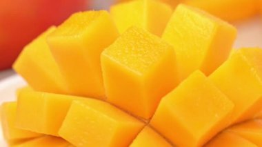 Güzel taze doğranmış mango, dönen beyaz plaka üzerinde gösteren, yakın çekim, 4k video çekim.