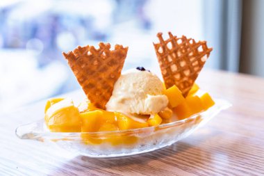 Yaz restoran, yaşam tarzı, Tayvan popüler gıda dondurma ve meyve suyu sosu bir kepçe ile taze mango, yakın.