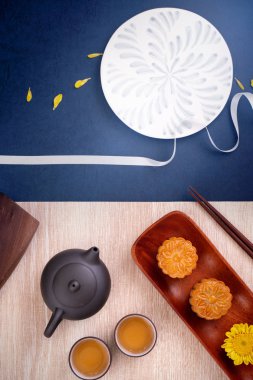 Yaratıcı Ay kek Mooncake tasarım ilham, ahşap masa konsepti pasta ve çay ile Sonbahar ortası festivalinde ay keyfini, üst görünüm, düz yatıyordu