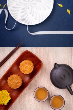 Yaratıcı Ay kek Mooncake tasarım ilham, ahşap masa konsepti pasta ve çay ile Sonbahar ortası festivalinde ay keyfini, üst görünüm, düz yatıyordu