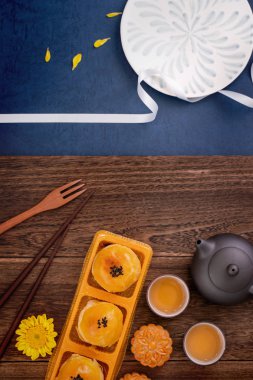 Yaratıcı Ay kek Mooncake tasarım ilham, ahşap masa konsepti pasta ve çay ile Sonbahar ortası festivalinde ay keyfini, üst görünüm, düz yatıyordu