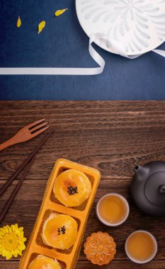 Yaratıcı Ay kek Mooncake tasarım ilham, ahşap masa konsepti pasta ve çay ile Sonbahar ortası festivalinde ay keyfini, üst görünüm, düz yatıyordu