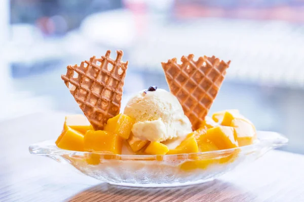 Fresh mango shaved ice with a scoop of ice cream and juice sauce in summer restaurant, lifestyle, popular food in Taiwan, close up.