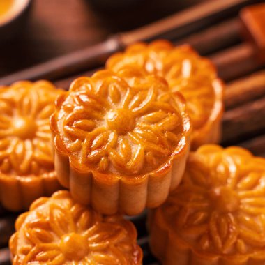 Orta Sonbahar Festivali için ahşap arka plan üzerinde bambu porsiyon uyarı tepsisi üzerinde çay bardak ile Çin geleneksel pasta Moon cake Mooncake, yakın.