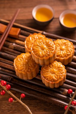 Orta Sonbahar Festivali için ahşap arka plan üzerinde bambu porsiyon uyarı tepsisi üzerinde çay bardak ile Çin geleneksel pasta Moon cake Mooncake, yakın.